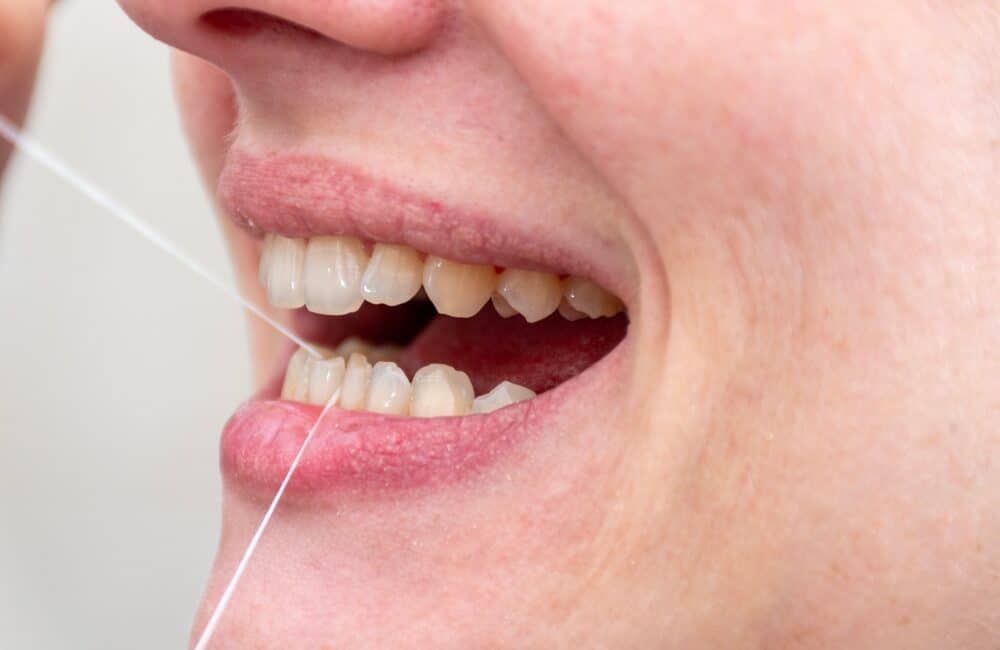 Osoba nitkująca zęby